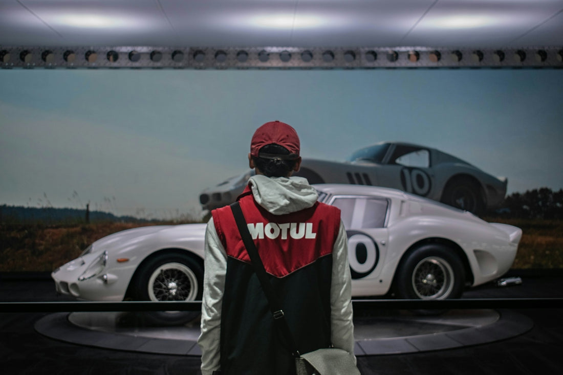 Person in motul vest looks at vintage race cars